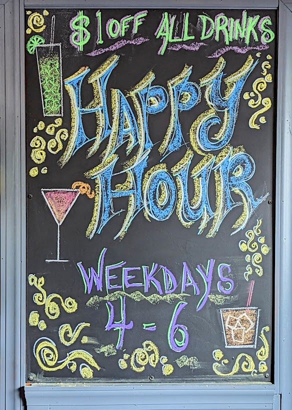 A chalkboard sign that says happy hour.